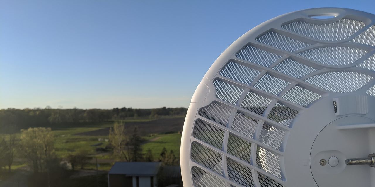 A Stalwart Wireless antenna on a rooftop, looking out over farm fields under a clear sky